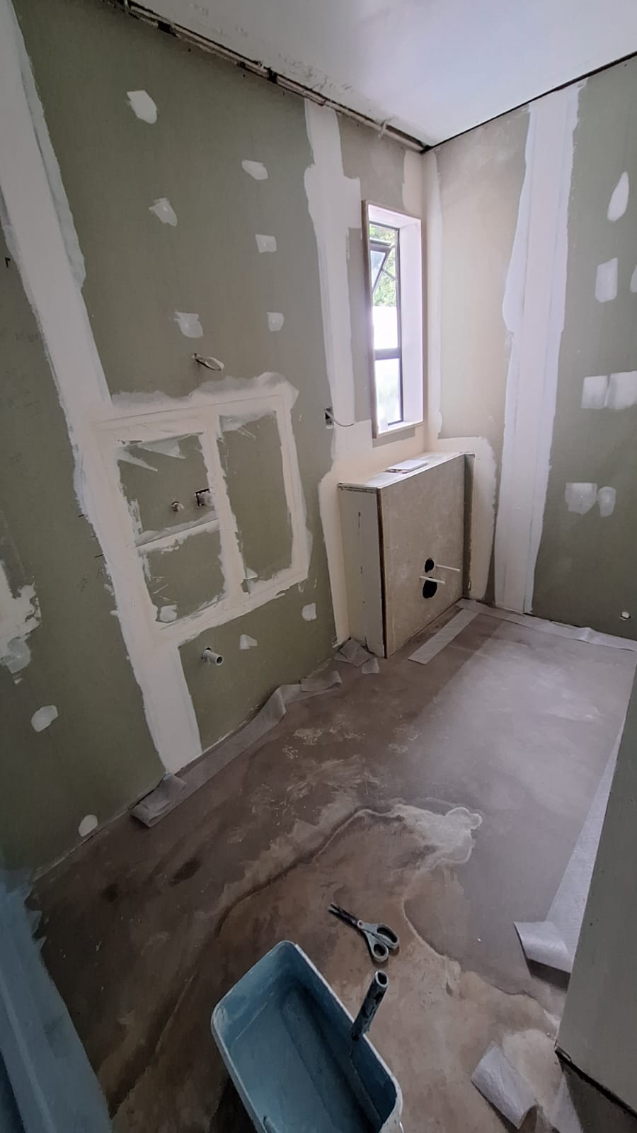Bathroom stripped back to plasterboard with sealed floor and toilet cistern frame ready for waterproofing in Auckland