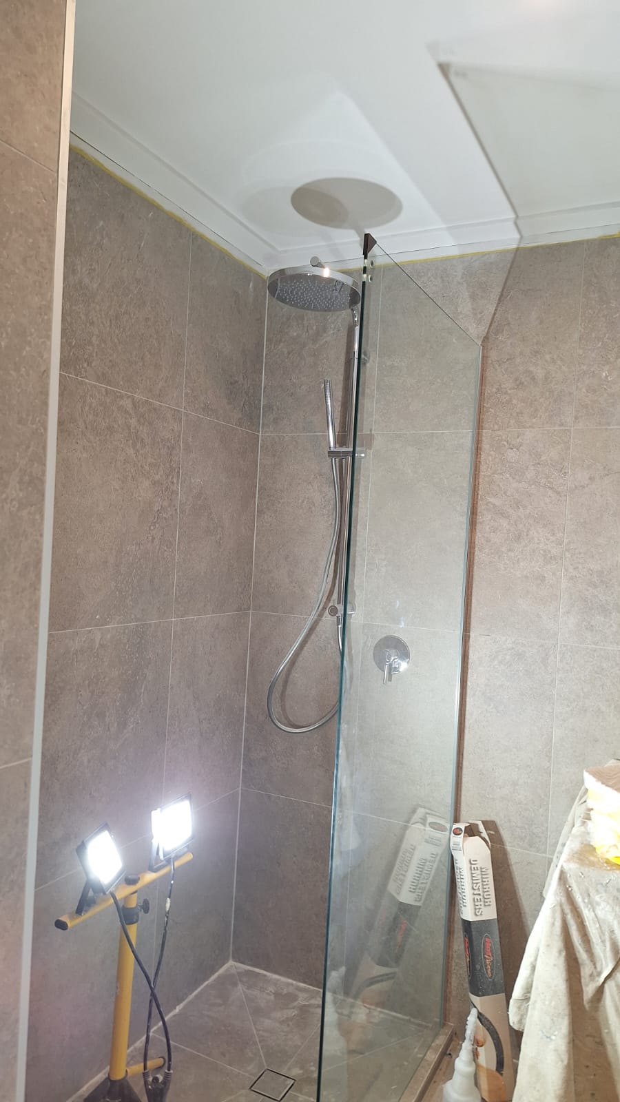 New tiled shower with frameless glass screen, rain shower head and hand shower installed during an Auckland shower replacement